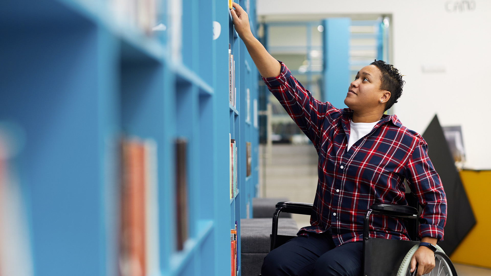 Wheelchair user choosing a book © Shutterstock