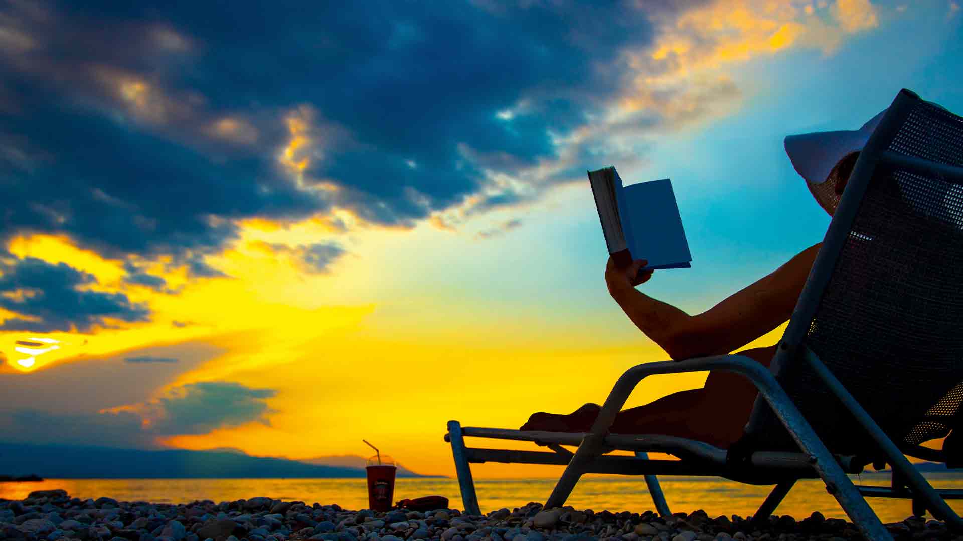 Woman reading on beach © Shutterstock